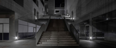 Un escalier dans l'obscurité menant à dédale de ciment